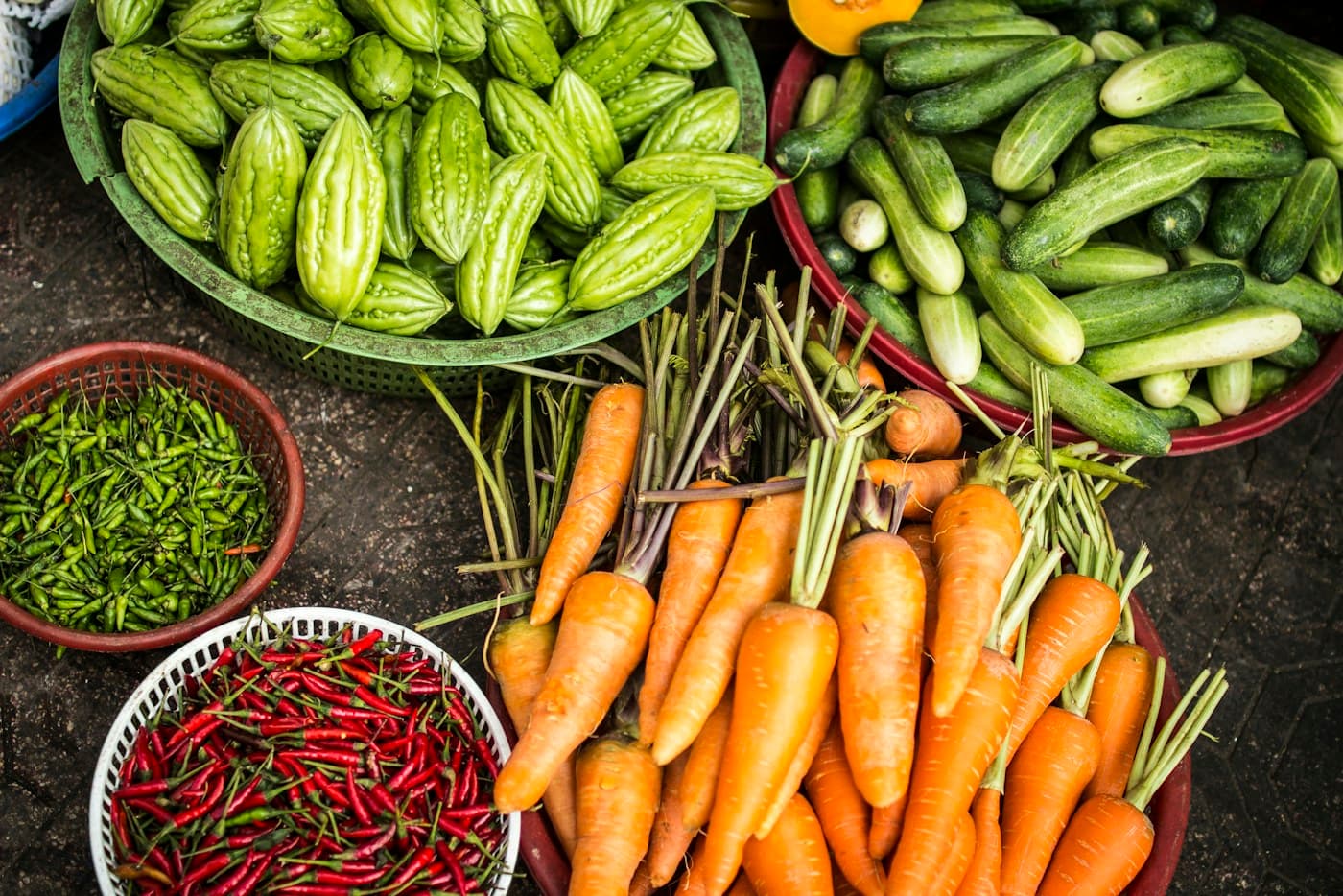 Harvested vegetables including carrots, cucumbers and peppers in baskets